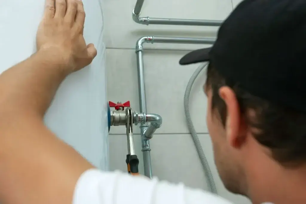 Technician servicing residential plumbing pipes