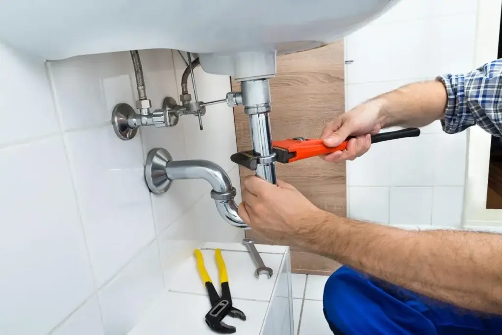 Plumber repairing a residential sink drain